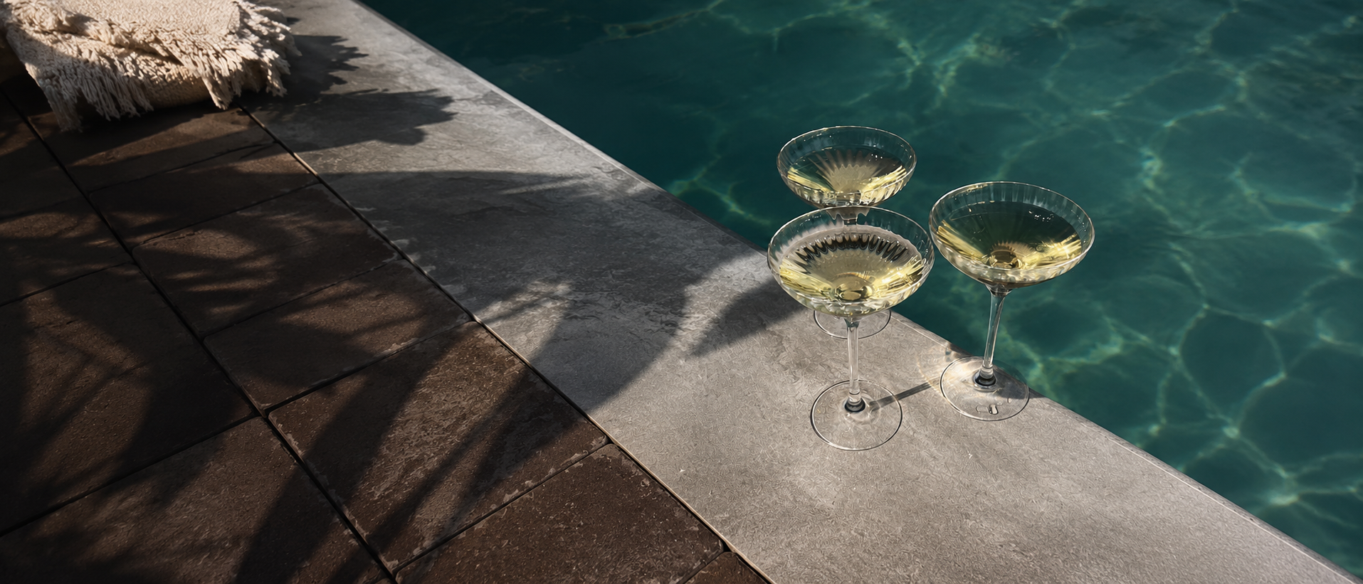 Elegant cocktail glasses beside a summer pool